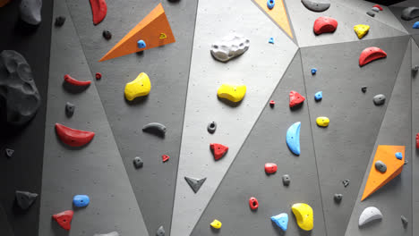 Loop-animation-of-artificial-climbing-or-bouldering-wall.-Rock-extreme-sport-activity-for-indoor-training-and-exercise-at-leisure-time.-Loopable-empty-gym-with-many-colorful-holds.