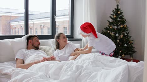 Un-Niño-Feliz-Despierta-A-Sus-Padres-En-La-Mañana-De-Navidad.-Familia,-Vacaciones-De-Invierno-Y-Concepto-De-Personas.-Un-Niño-Feliz-Despierta-A-Su-Madre-Y-A-Su-Padre-En-La-Mañana-De-Navidad.