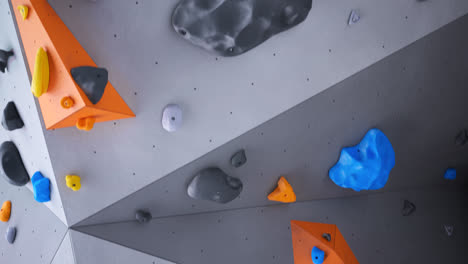 Loop-animation-of-artificial-climbing-or-bouldering-wall.-Rock-extreme-sport-activity-for-indoor-training-and-exercise-at-leisure-time.-Loopable-empty-gym-with-many-colorful-holds.