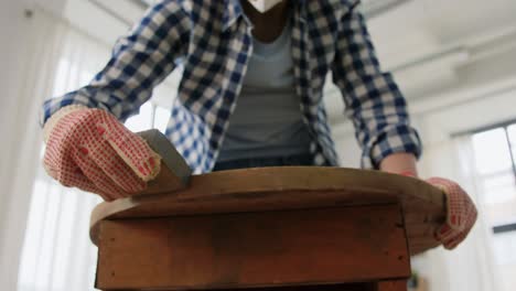 Woman-Sanding-Old-Round-Wooden-Table-with-Sponge.renovation,-diy-and-home-improvement-concept--woman-sanding-old-round-wooden-table-with-sponge