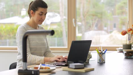 Young-Woman-is-Working-at-Home-on-a-Laptop.focused-woman-wearing-glasses-typing-over-the-keyboard-of-her-laptop-while-sitting-at-home.-concentrated-female-freelancer-working.-remote-work,-self-employment-and-study,-solving-task,-research.