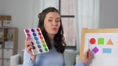 Lehrerin-Mit-Farben,-Die-Online-Kunstunterricht-Hat.-Fernunterricht,-Grundschule-Und-Unterrichtskonzept.-Lehrerin-Mit-Farben-Und-Einem-Bild-Eines-Regenbogens,-Die-Zu-Hause-Online-Kunstunterricht-Hat.