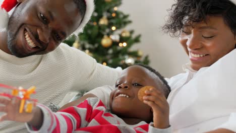 Feliz-Familia-Africana-Jugando-Con-Juguetes-En-Navidad.-Familia,-Vacaciones-De-Invierno-Y-Concepto-De-Personas.-Feliz-Madre,-Padre-E-Hijo-Afroamericanos-Jugando-Con-Un-Avión-De-Juguete-En-Casa-En-Navidad