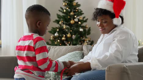 Madre-E-Hijo-Abriendo-Un-Regalo-De-Navidad-En-Casa.-Familia,-Vacaciones-De-Invierno-Y-Concepto-De-Personas.-Feliz-Madre-Afroamericana-Y-Su-Hijo-Abriendo-Una-Caja-De-Regalo-En-Casa-En-Navidad.