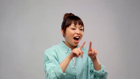 Happy-Asian-Woman-Dancing-with-Glowing-Lines.leisure-and-people-concept--happy-asian-woman-dancing-over-grey-background-with-animated-glowing-neon-lines