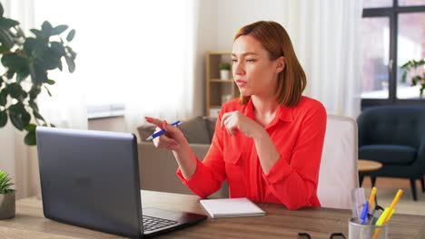 Junge-Frau-Führt-Zu-Hause-Einen-Videoanruf-Am-Laptop.-Handaufnahme-Aus-Niedriger-Perspektive,-Freiberufliche-Mitarbeiterin-Erklärt-In-Einem-Online-Meeting-Mit-Teammitgliedern-Am-Laptop-Im-Homeoffice-Ein-Projekt.-Arbeiten-Von-Zu-Hause,-Remote-Arbeit.