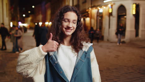 Glückliches-Teenager-Kind,-Das-Zustimmend-Aussieht-Und-Daumen-Hoch-Zeigt,-Wie-Ein-Zeichen-Für-Positives-Feedback-In-Der-Stadtstraße