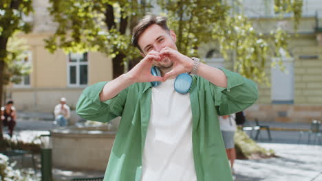 Man-makes-symbol-of-love-showing-heart-sign-to-camera-charity-gratitude-donation-positive-feelings