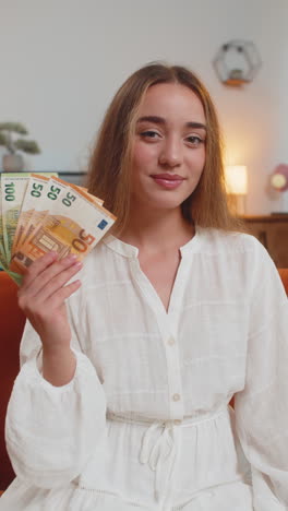 Successful-rich-happy-smiling-woman-holding-waving-euro-bills-money-fan-winning-online-lottery-game