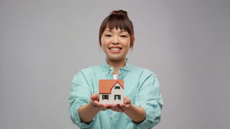 Portrait-of-a-Young-Asian-Woman-Business-Owner-Holding-Many-House-Plants-Smiling.Korean-young-woman-selfie-with-green-plants.-Portrait-of-a-young-asian-woman-business-owner-holding-many-house-plants-smiling-and-looking-at-camera-in-a-greenhouse.-Gardener-working-in-flower-shop