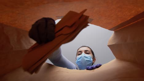 Mujer-Con-Guantes-Y-Mascarilla-Empacando-Comida-En-Bolsa-De-Papel.-Protección-De-La-Salud,-Concepto-De-Entrega-Y-Pandemia.-Mujer-Con-Guantes-Médicos-Protectores-Y-Mascarilla-Empacando-Comida-China-Para-Llevar-En-Una-Bolsa-De-Papel.