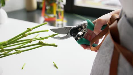 Close-Up-of-Woman-Arranging-Flowers-at-Home.people,-gardening-and-floral-design-concept-close-up-of-woman-arranging-flowers-and-cutting-stems-with-pruning-shears-at-home