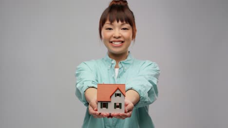 Portrait-of-a-Young-Asian-Woman-Business-Owner-Holding-Many-House-Plants-Smiling.Korean-young-woman-selfie-with-green-plants.-Portrait-of-a-young-asian-woman-business-owner-holding-many-house-plants-smiling-and-looking-at-camera-in-a-greenhouse.-Gardener-working-in-flower-shop