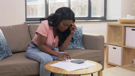 Close-Up-of-African-Woman-Making-Calculations-on-Paper-Calculator.The-Close-Up-of-African-Woman-making-Calculations-on-Paper,-Calculator