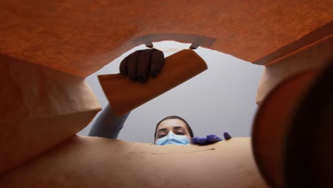 Mujer-Con-Guantes-Y-Mascarilla-Empacando-Comida-En-Bolsa-De-Papel.-Protección-De-La-Salud,-Concepto-De-Entrega-Y-Pandemia.-Mujer-Con-Guantes-Médicos-Protectores-Y-Mascarilla-Empacando-Comida-China-Para-Llevar-En-Una-Bolsa-De-Papel.