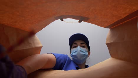 Mujer-Con-Guantes-Y-Mascarilla-Empacando-Comida-En-Bolsa-De-Papel.-Protección-De-La-Salud,-Concepto-De-Entrega-Y-Pandemia.-Mujer-Con-Guantes-Médicos-Protectores-Y-Mascarilla-Empacando-Comida-China-Para-Llevar-En-Una-Bolsa-De-Papel.