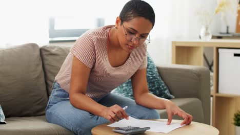 Close-Up-of-African-Woman-Making-Calculations-on-Paper-Calculator.The-Close-Up-of-African-Woman-making-Calculations-on-Paper,-Calculator