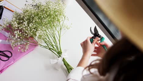 Close-Up-of-Woman-Arranging-Flowers-at-Home.people,-gardening-and-floral-design-concept-close-up-of-woman-arranging-flowers-and-cutting-stems-with-pruning-shears-at-home