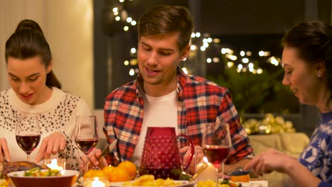 Concepto-De-Vacaciones-Y-Celebración.-Amigos-Felices-Cenando-En-Casa-Y-Comiendo-En-Navidad.