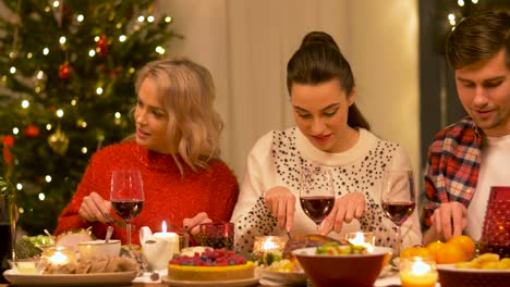 Feiertage-Und-Festkonzept-Glückliche-Freunde,-Die-Zu-Hause-Weihnachtsessen-Haben-Und-Essen