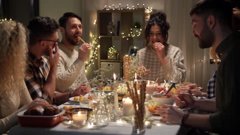 Concepto-De-Vacaciones-Y-Celebración.-Amigos-Felices-Cenando-En-Casa-Y-Comiendo-En-Navidad.