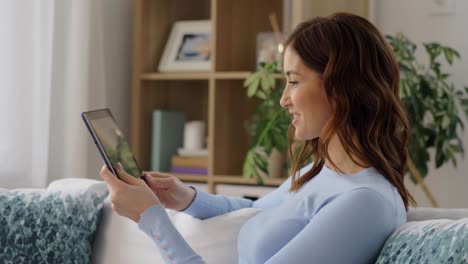 Concepto-De-Gente,-Tecnología-Y-Ocio.-Feliz-Joven-Afroamericana-Sentada-En-Un-Sofá-Con-Una-Computadora-Tablet-Haciendo-Una-Videollamada-Y-Saludando-Con-La-Mano-En-Casa