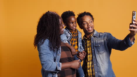 Dulce-Familia-Feliz-Con-Un-Niño-Pequeño-Tomándose-Fotos-Con-Un-Teléfono-Inteligente