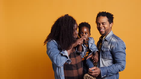 African-american-parents-teaching-their-sweet-toddler-to-sing-on-microphone