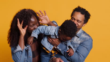 Portrait-of-african-american-family-with-a-young-kid-in-studio