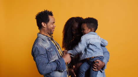 African-american-positive-couple-doing-peek-a-boo-with-their-young-child