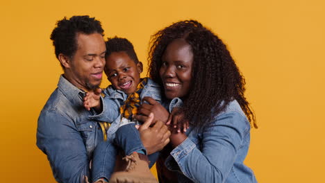 African-american-family-and-their-little-child-in-studio-holding-each-other