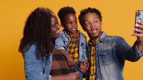 Mother-and-father-taking-photos-with-their-cute-toddler-on-smartphone