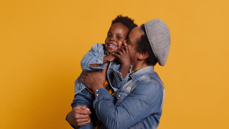 African-american-father-and-cute-toddler-having-fun-together-in-studio