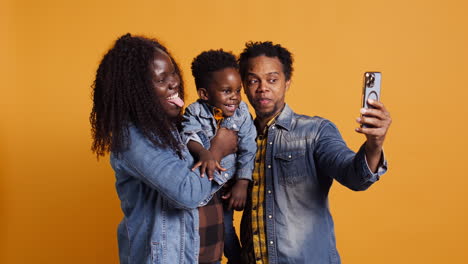 African-american-family-of-three-smiling-for-photos-on-mobile-phone