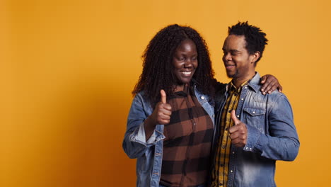 Affectionate-husband-and-wife-giving-a-like-symbol-on-camera