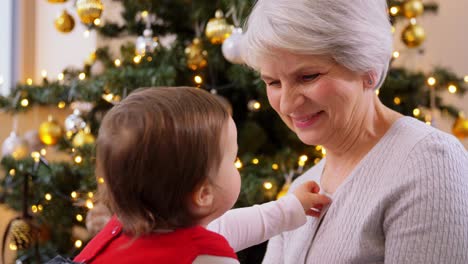 Großmutter-Und-Kleines-Mädchen-Zu-Hause-An-Weihnachten.Weihnachten,-Feiertage-Und-Familienkonzept.-Glückliche-Großmutter-Und-Kleine-Enkelin-Zu-Hause