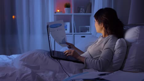 Frau-Mit-Brille-Arbeitet-Am-Laptop,-Während-Sie-Nachts-Im-Bett-Liegt.-Frau-Mit-Brille-Arbeitet-Am-Laptop,-Während-Sie-Nachts-Im-Bett-Liegt.-Konzept-Der-Internetsucht-Oder-Schlaflosigkeit.