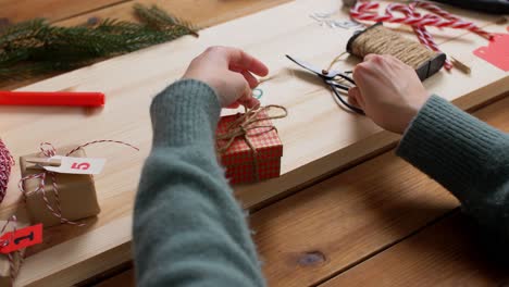 Hände,-Die-Zu-Hause-Einen-Adventskalender-Für-Weihnachten-Basteln.Winterferien-Und-Hobbykonzept-Hände-Mit-Schachtel-Und-Seil,-Die-Zu-Hause-Einen-Adventskalender-Basteln-Oder-Weihnachtsgeschenke-Verpacken