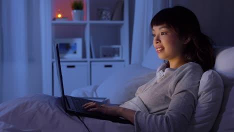 Woman-in-Glasses-Working-on-Laptop-While-Lying-in-Bed-at-Night.Woman-in-glasses-working-on-laptop-while-lying-in-bed-at-night.-Internet-addict-or-insomnia-concept.