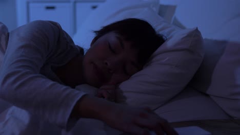 Mujer-Dormida-Que-Se-Despierta-Por-El-Teléfono-Por-La-Noche.-Tecnología,-Internet,-Comunicación-Y-Concepto-De-Personas.-Mujer-Afroamericana-Joven-Durmiendo-En-La-Cama-Y-Despertándose-Por-El-Teléfono-Inteligente-En-Casa-Por-La-Noche.