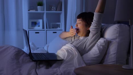 Müde-Frau,-Die-Ihren-Laptop-Zuklappt-Und-Im-Bett-Schläft.Technologie,-Internet,-Kommunikation-Und-Menschen-Konzept-Müde-Junge-Asiatische-Frau,-Die-Ihren-Laptop-Zuklappt-Und-Sich-Nachts-Zu-Hause-Ins-Bett-Legt,-Um-Zu-Schlafen