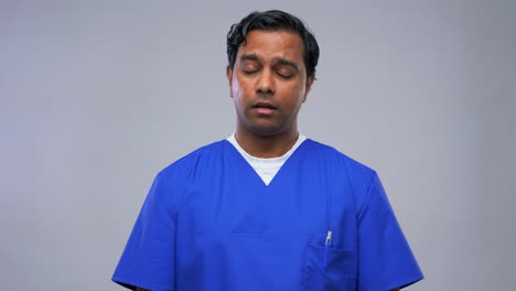 Indian-Doctor-or-Male-Nurse-Having-Video-Call.healthcare,-medicine-and-communication-concept-indian-doctor-or-male-nurse-in-blue-uniform-having-video-conference-over-grey-background