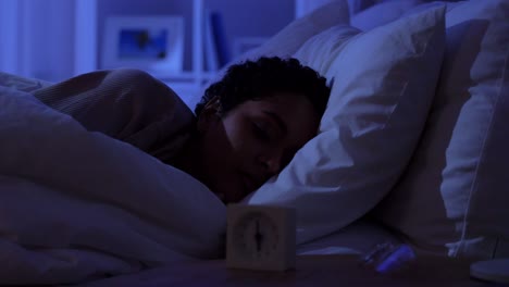 Woman-Awaking-Because-of-Alarm-Clock-at-Night.people,-bedtime-and-rest-concept-african-american-woman-awaking-because-of-alarm-clock-at-night