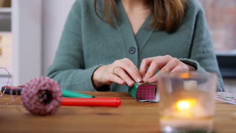 Hände,-Die-Zu-Hause-Einen-Weihnachts-Adventskalender-Basteln.-Winterferien,-Weihnachts--Und-Hobbykonzept-Hände,-Die-Eine-Geschenkbox-Mit-Etikett-An-Einen-Handgefertigten-Adventskalender-Zu-Hause-über-Schnee-Hängen