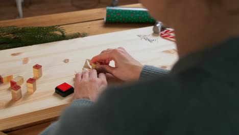 Woman-Making-Advent-Calender-on-Christmas-at-Home.winter-holidays-and-hobby-concept-creative-woman-with-stamps-making-advent-calender-on-christmas-at-home