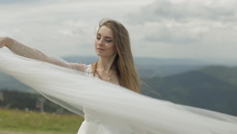 Beautiful-bride-in-wedding-dress-and-veil-on-the-mountains.-Slow-motion