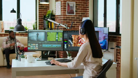 Asian-filmmaker-woman-putting-headphones-on-and-working-on-video-production