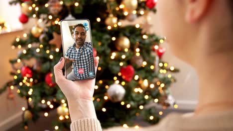 Woman-with-Smartphone-Has-Video-Call-on-Christmas.christmas,-technology-and-holidays-concept-–-close-up-of-young-woman-with-smartphone-having-video-with-senior-mother-call-at-home