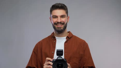 Male-Photographer-Taking-Studio-Portraits-on-Digital-Camera.Back-view-arc-shot-of-professional-male-photographer-taking-studio-portrait-photo-samples-on-dslr-camera-and-looking-at-pictures-on-computer-monitor-while-working-with-assistant-indoors