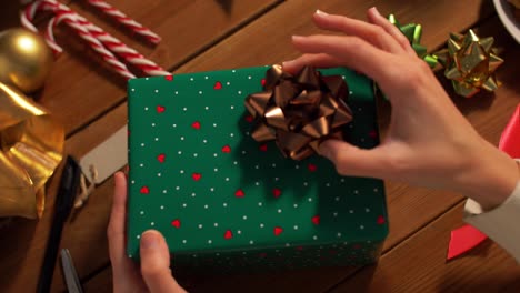 Hände-Packen-Weihnachtsgeschenke-Und-Wählen-Schleife-Aus.-Feiertage,-Neujahr-Und-Weihnachtskonzept-–-Hände-Packen-Geschenkboxen-Und-Wählen-Schleife-Zu-Hause-über-Schnee-Aus